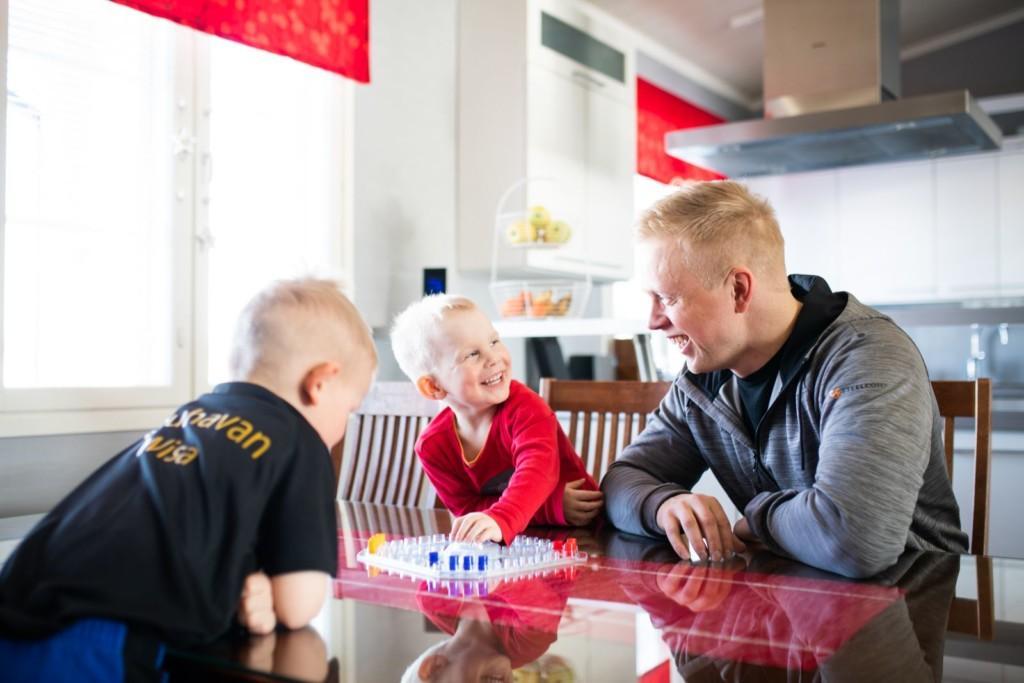 Iisakki Kankaanpää pelaa lautapeliä lastensa kanssa